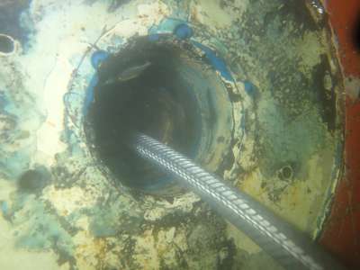 Hose feeding into a circular transducer pocket in a ship's hull underwater