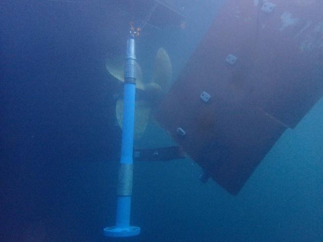 Rudder and propeller underwater with a blue support column installed for repair