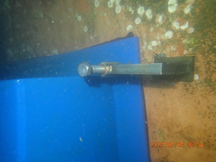 Blue cofferdam plate secured to a ship's hull with a threaded stud underwater